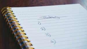 An open spiral-bound notebook shows a numbered to-do list headed “Today.”