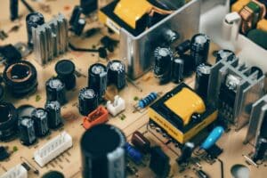 Close-up of a circuit board with various electronic components, including capacitors, resistors, and transformers. The board's complexity suggests the inner workings of a device, possibly related to hanging Christmas lights on a roofline.